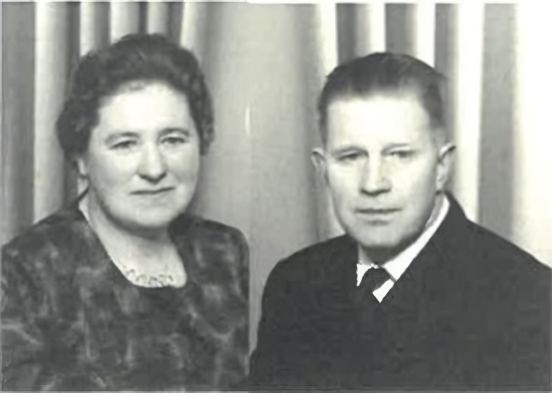 To personer i gammel bilde; en kvinne med bluse og en mann med dress