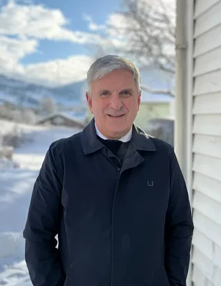 Mann med svart frakk og lyst hår