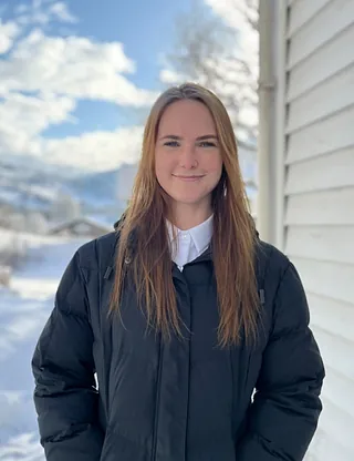 Kvinne med svart jakke og blondt hår